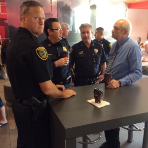 An officer considers drawing his weapon as he fearfully eyes the camera pointed at him.