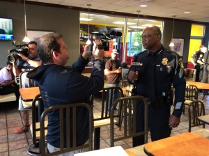 Chief McClelland is assisted by camera specialists in his struggle to find an appropriately authoritarian pose.